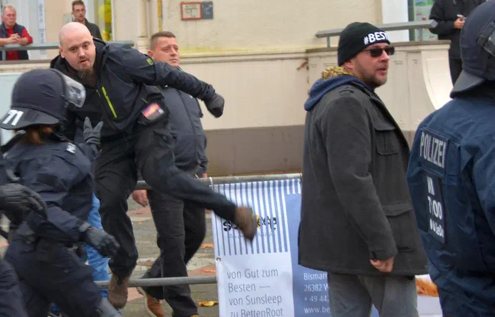 Jens Malte Hillers aus Wilhelmshaven, langjähriger Neonaziaktivist, überspringt das Absperrgitter, um Gegendemonstrant_innen anzugreifen.