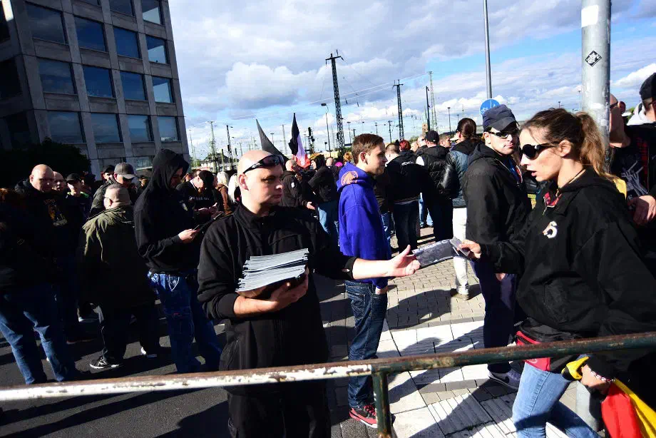 Ein Mitglied der Neonazigruppierung "Bürger gegen Politikwahnsinn" (BgP) beim Verteilen von Verkaufskatalogen der Rechtsrockband "Kategorie C"...  