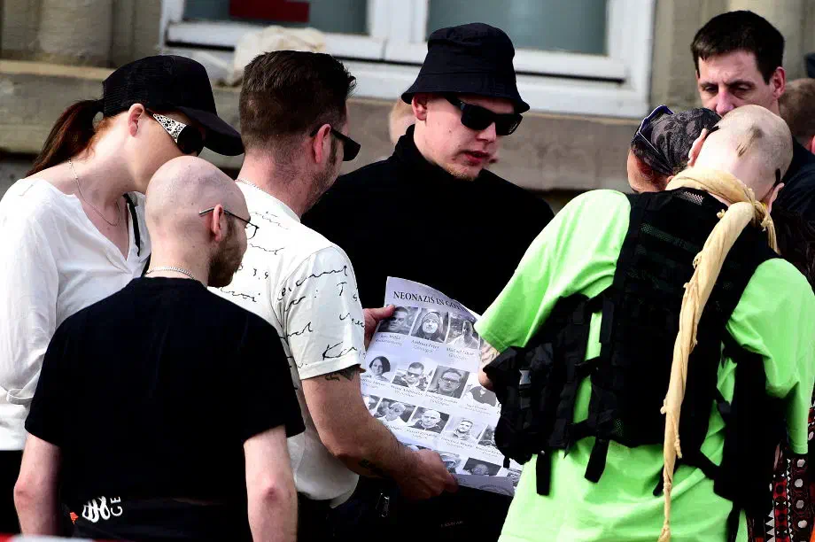 Vor Beginn der eigentlichen Kundgebung wurden unter den angereisten Teilnehmer*innen Plakate verteilt. Dabei handelt es sich um sogenannte "Outing Plakate" des eigenen Klientels.