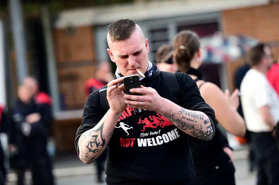 Neonazi mit auf dem Unterarm tätowierter "Triskele", welches in der Neonaziszene als Ersatz für das verbotene Hakenkreuz genutzt wird. Die Triskele zierte in der Vergangenheit das Wappen der flämischen "SS-Division Langemarck" 