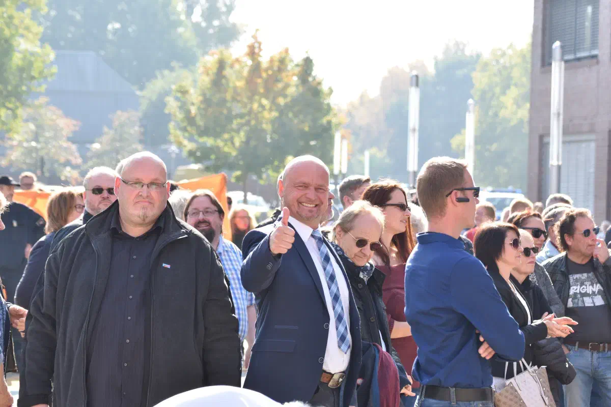 Wenige Minuten später kippt seine Stimmung als er erfährt, dass er nicht über den Besuch des Bundestagsabgeordneten Dietmar Friedhoff (Bildmitte) informiert wurde. Links im Bild ist der Wilhelmshavener Frank Appeldorn zu sehen, der zum Schtz von Herrn Friedhoff abgestellt wurde.