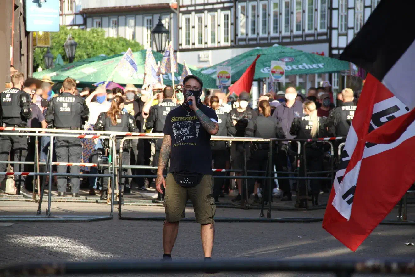 Anschließend sprach Johannes Welge, Vorsitzender des Kreisverbandes Braunschweig-Hildesheim. Die wenigen Wortfetzen, die trotz des lautstarken Gegenprotests zu verstehen waren, bezogen sich auf den Sprengstoffanschlag, den 2 Neofaschisten am Haus einer Frau, die sich in Einbeck gegen neonazistische Umtriebe engagiert, begangen haben. Beide Täter können dem Kreisverband  Einbeck der Partei „Die Rechte“ zugeordnet werden. Welge versuchte den Anschlag zu relativieren und in kurzen Sätzen abzuhandeln, bevor er anfing von der „großen Idee“ zu fabulieren, „die alle wieder einen würde.“
