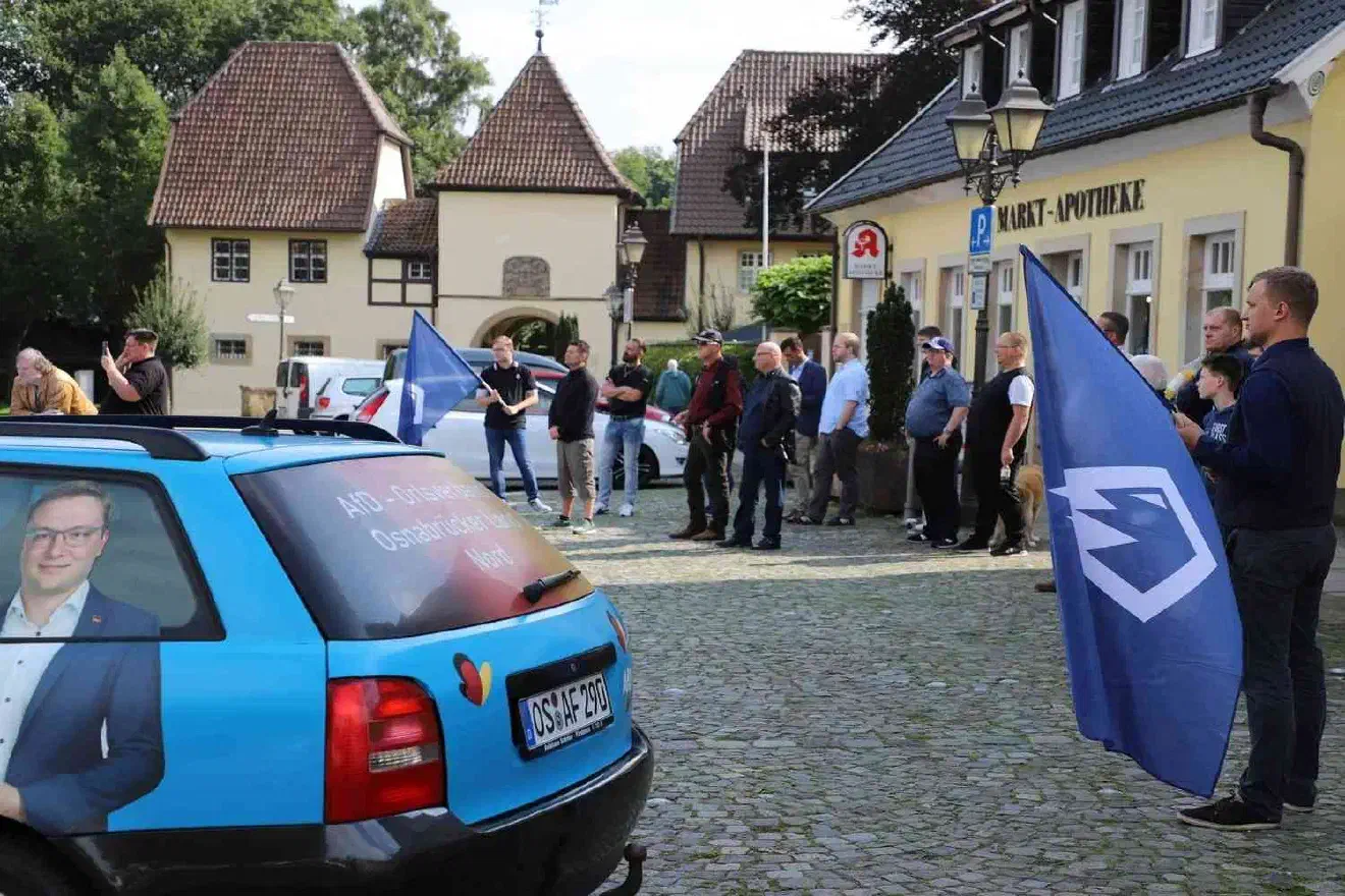 Insgesamt machte die Kundgebung trotz der beiden JA-Fahnen und des JA-Infotischs mehr den Eindruck einer AfD- als einer JA-Veranstaltung. Es liegt nahe, dass der Veranstaltung das Etikett „JA“ nur angeklebt wurde, um darüber hinweg zu täuschen, dass es dem AfD Kreisverband Osnabrück nicht gelungen ist, eine:n AfD- Landes- oder Bundespolitiker:in als Redner:in nach Bersenbrück zu bekommen.