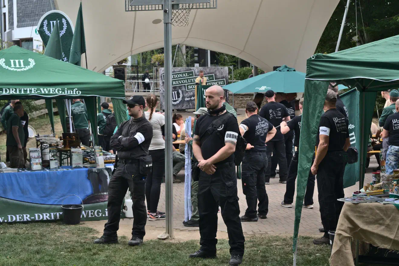 Diese Ansprache nutzte Julian Bender, um sich kämpferisch zu präsentieren. Die Polizei hat verlangt die Demonstration auf der Wiese und nicht auf der zuvor angedachten Straße aufzustellen. Bender meinte dass das so nicht passieren würde und die Sammlung auf der Straße stattfinden werde.