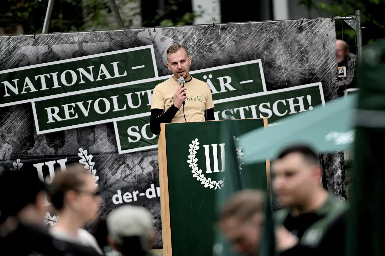 Nach der letzten Ansprache, dass die Demonstration sich auf jeden Fall auf der Straße sammeln würde und nicht auf der Wiese, rief Bender hier dazu auf auf der Wiese Aufstellung zu nehmen.