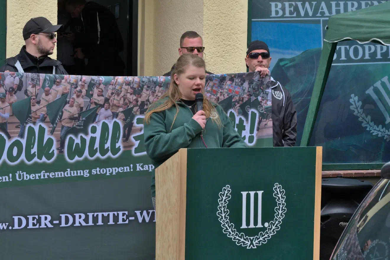 Bei dieser Rednerin handelte es sich um die Neonaziaktivistin Christin Weiß. Sie trat auch als Versammlungsleitung in Erscheinung..