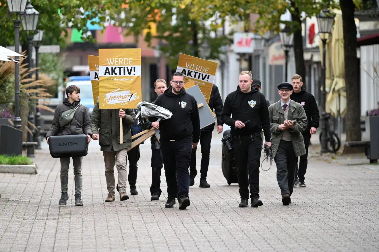 Der Veranstaltungsbeginn der ersten Kundgebung war auf 11 Uhr veranschlagt. Angeführt von ihrem Bundesvorsitzenden Sebastian Weigler (Bildmitte, mit Brille) erschienen kurz vor Beginn dann etwa ein dutzend Mitglieder der Jugendorganisation "Junge Nationalisten" (JN). Diese rekrutierten sich dabei aus dem JN-Regionalverband Nord und kamen vorwiegend aus Niedersachsen und Schleswig-Holstein.