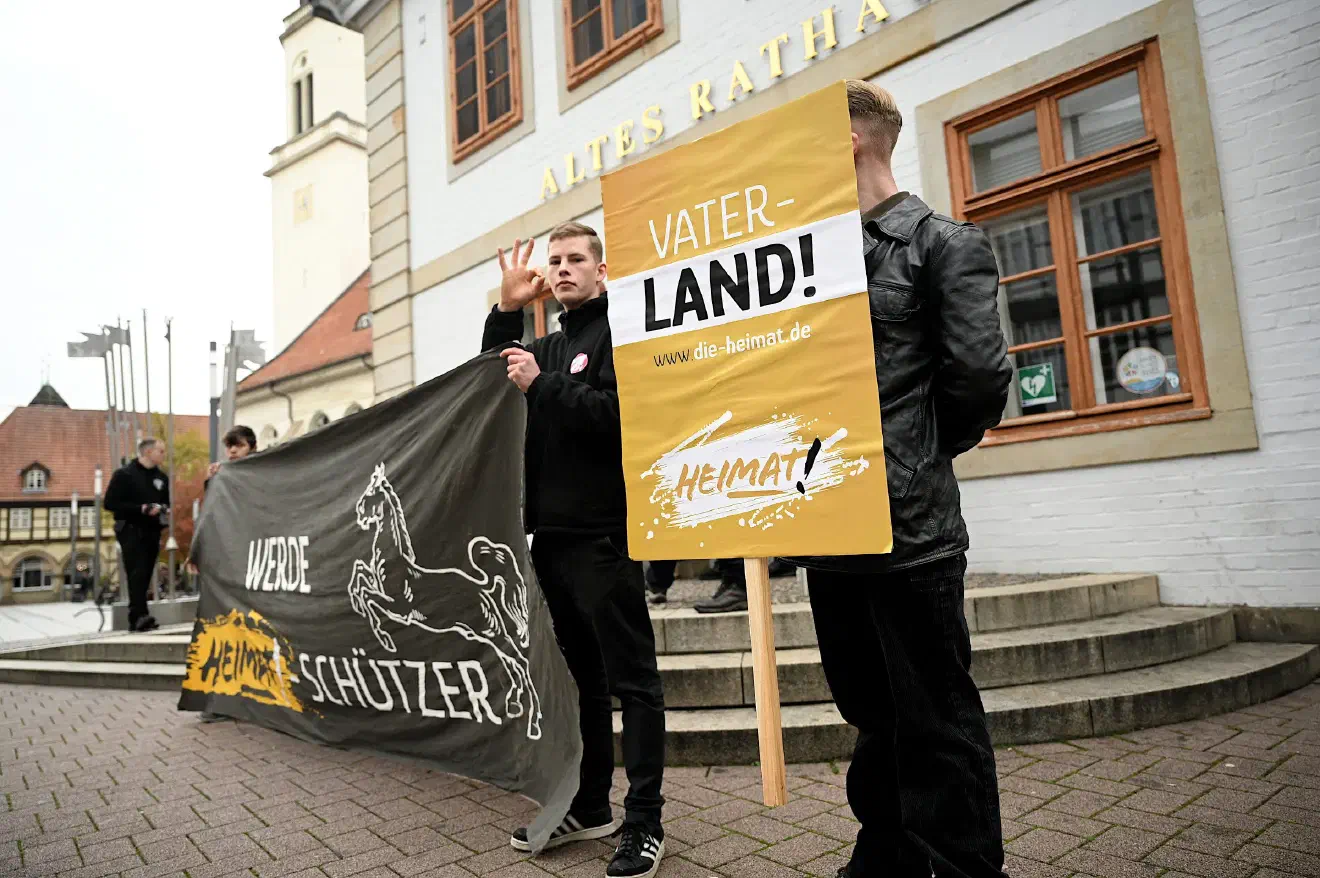 Ein JN-Aktivist aus Braunschweig zeigte den sogenannten White-Power-Gruß - eine innerhalb der Neonaziszene häufig verwendte Grußformel die an ein OK-Zeichen erinnert, innerhalb der eigenen Strukturen aber als rassistisches Bekenntnis unter Gleichgesinnten erkannt wird.