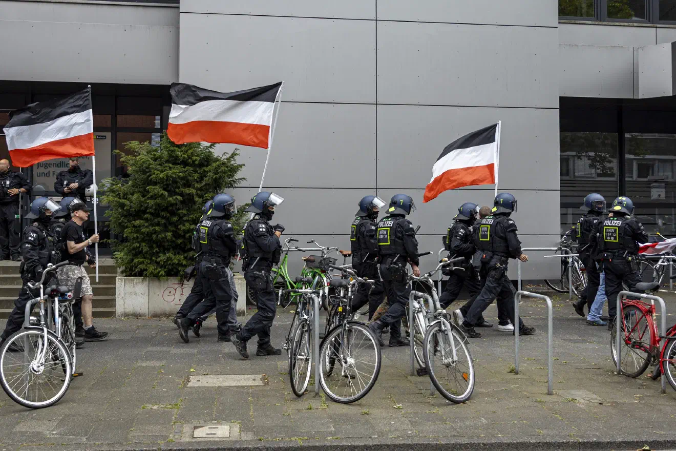 Noch während der entsprechenden Durchsage der Polizei begannen die Neonazis hektisch, die Reichsfahnen einzusammeln und im Lautsprecherfahrzeug zu verstauen.