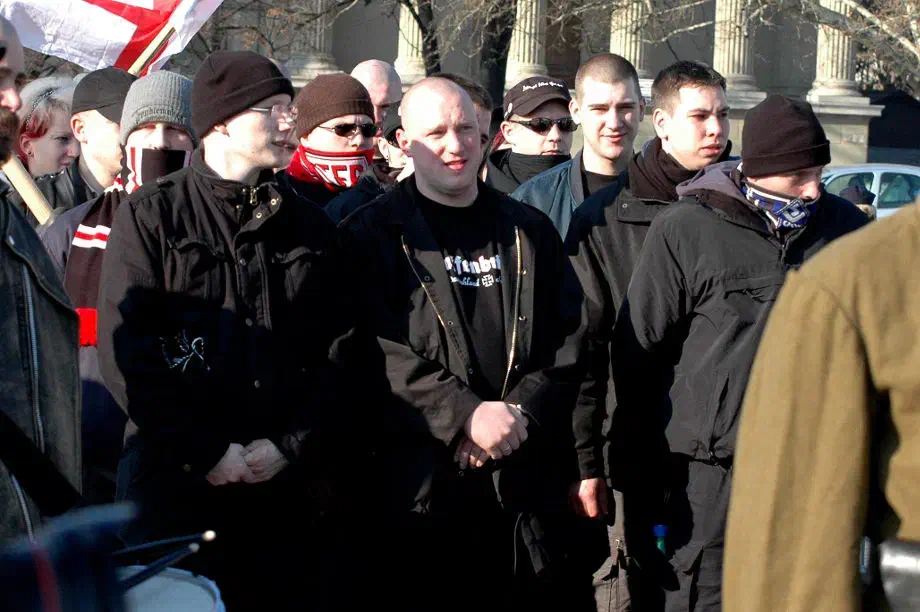 Auch Aktivisten der "Kameradschaft Süd" beteiligten sich in der Vergangenheit an der "Blood & Honour"-Veranstaltung "Day of Honour". Gegründet wurde die "Kameradschaft Süd – Aktionsbüro Süddeutschland" (AS) im Dezember 2001 durch den Neonazi Norman Bordin (Bildmitte: Norman Bordin während des "Day of Honour", 2007). Nachdem Bordin eine 15-monatige Haftstrafe annehmen musste, wurde die Gruppe vom Neonazi Martin Wiese übernommen. Mehrere Mitglieder dieser Vereinigung wurden wegen eines geplanten Sprengstoffattentats bei der Grundsteinlegung für das Jüdische Zentrum München im September 2003 festgenommen. Weitere Anschläge waren auf Moscheen, eine griechische Schule in München und Asylbewerberheime geplant. Insgesamt wurden 14 Kilogramm Sprengstoff sichergestellt, darunter 1,7 Kilogramm TNT. 